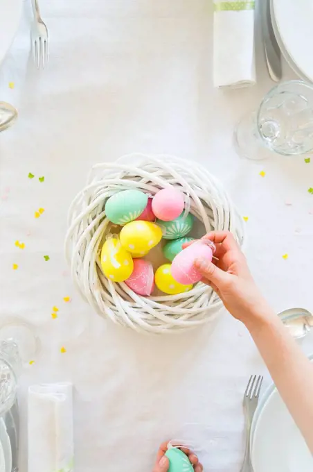 Little girl decorating dining table with Easter eggs