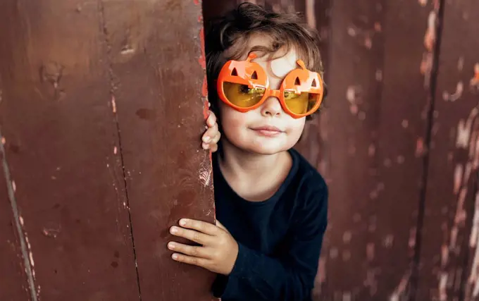 Portrait of little girl wearing halloween glasses shaped like pumpkins