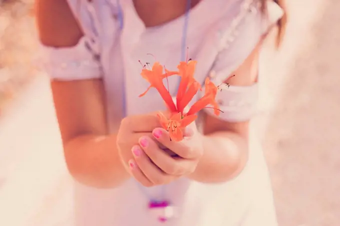 Girl holding orange blossom in her hands, close-up