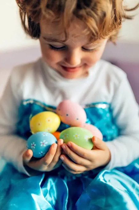 Happy little girl holding Easter eggs