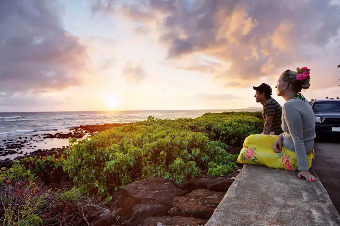 USA, Hawaii, Mid adult couple watching sundown by sea