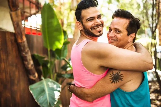 Portrait of happy gay couple arm in arm
