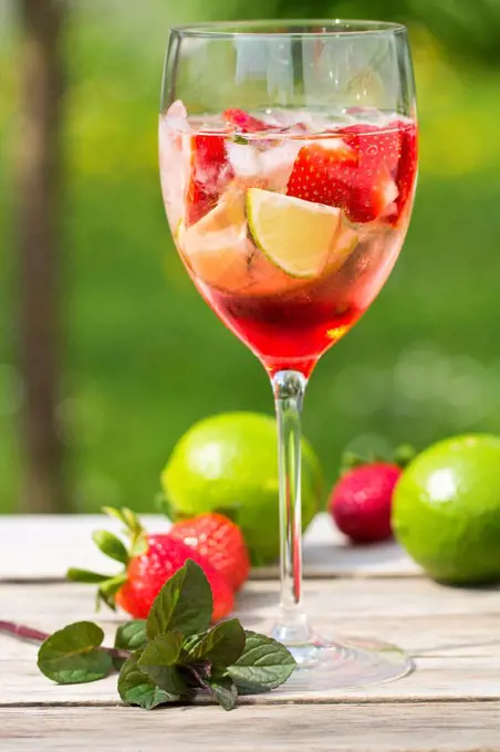 Glasses with ice, strawberry, lime, grenadine and prosecco