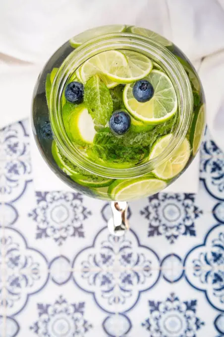 Glass of infused water with lime, blueberries and mint