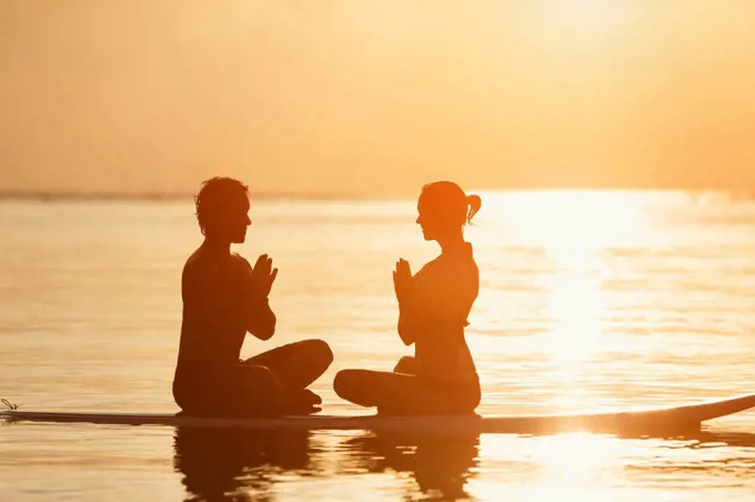 Thailand, yoga meditation on paddleboard at sunset