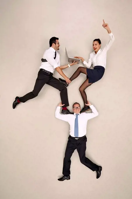 Businessman carrying his two male colleagues on his shoulders