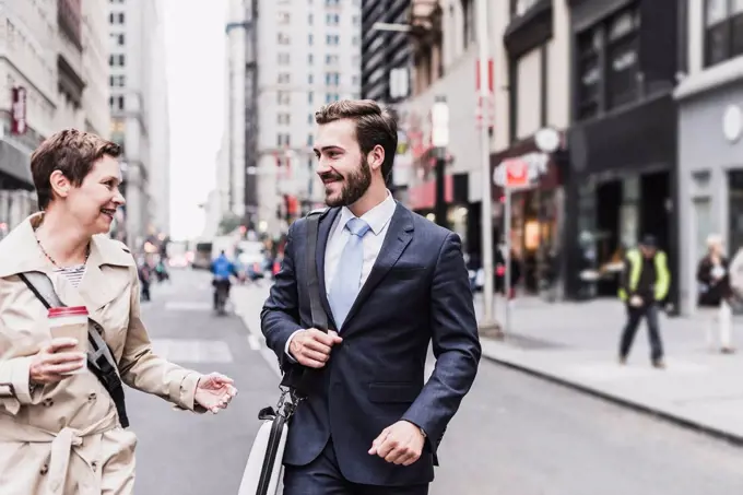 USA, New York City, businessman and woman walking in Manhattan