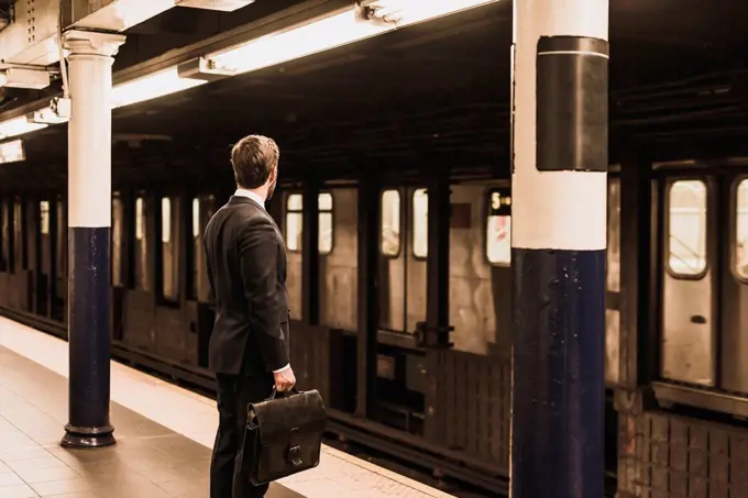Young businessman waiting at metro station platform
