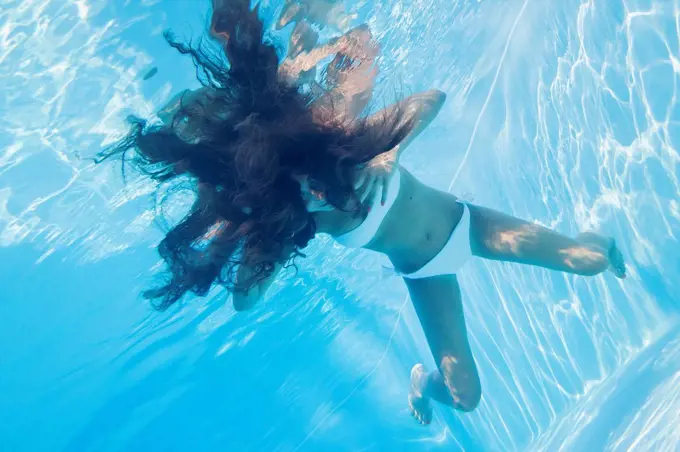 Young woman underwater in a pool