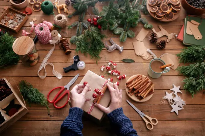 Woman's hands decorating Christmas present