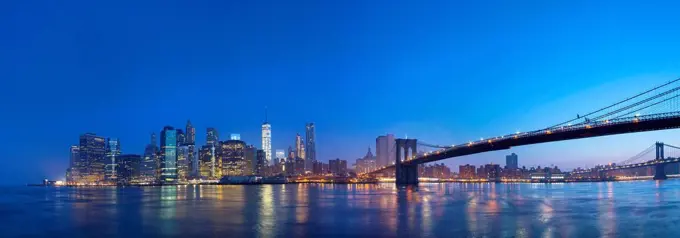 USA, New York City, Manhattan, panorama of financial district with Brooklyn Bridge at dawn