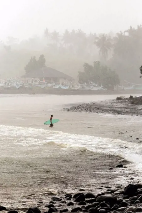 Indonesia, Bali, surfer carrying surfboards in the sea