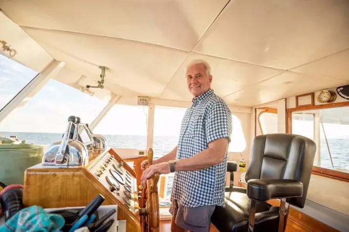 Confident senior man steering a boat