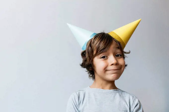 Portrait of little boy with two party hats on his head