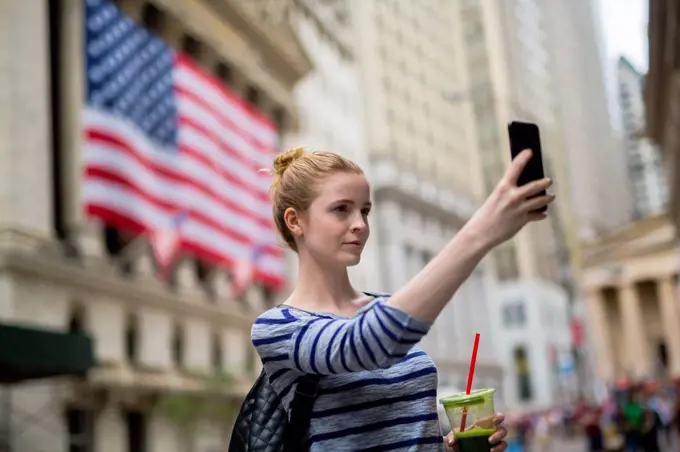 USA, New York City, woman taking selfie in front of New York Stock Exchange