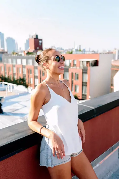 Relaxed woman standing on rooftop in Brooklyn