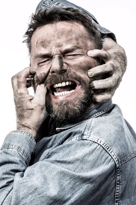 Portrait of screaming man with dirty face