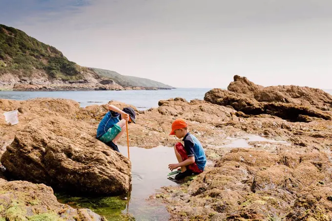UK, England, Cornwall, Polkerris beach, two boys fishing at the coast