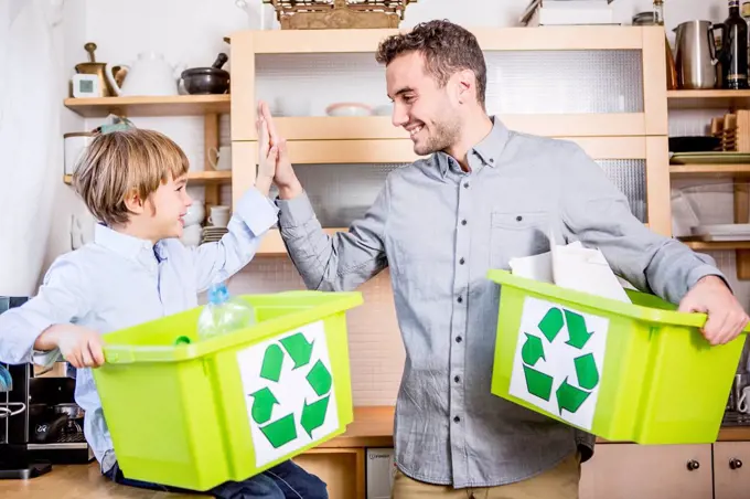 Father and son at home with waste boxes