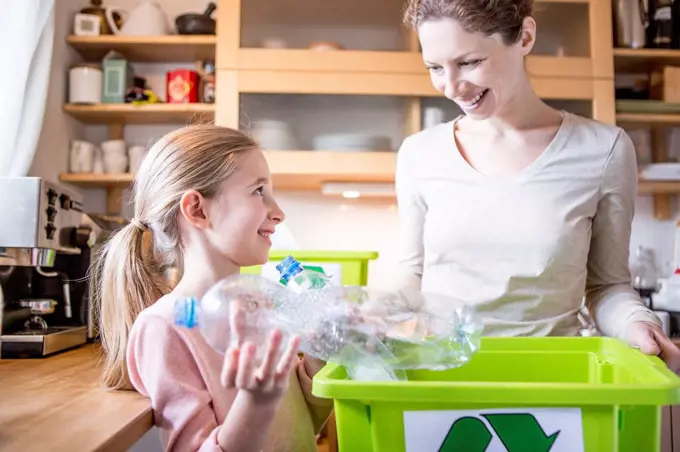 Mother and daughter at home separating waste