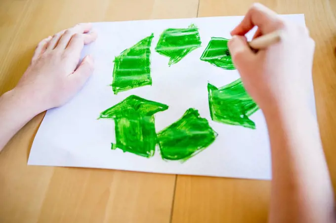 Close-up of girl painting recycling symbol