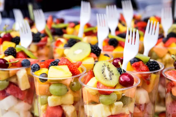 Plastic cups of fruit salad on street market