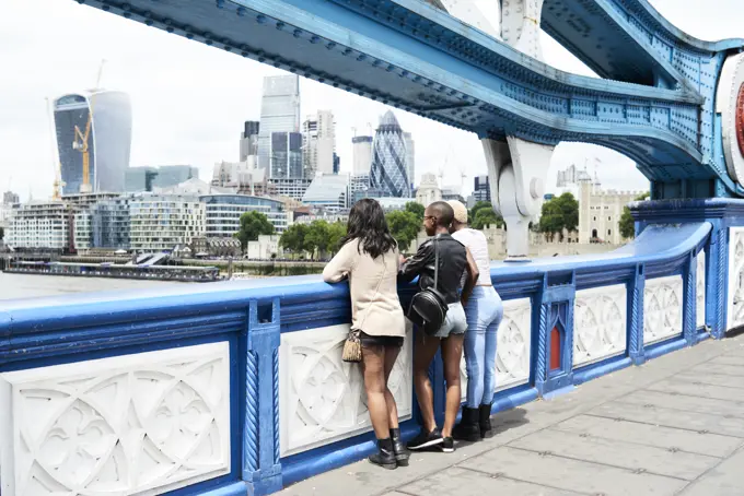 UK, London, back view of three friends looking at skyline