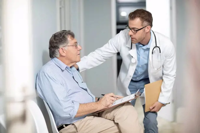 Doctor talking to patient with file in medical practice