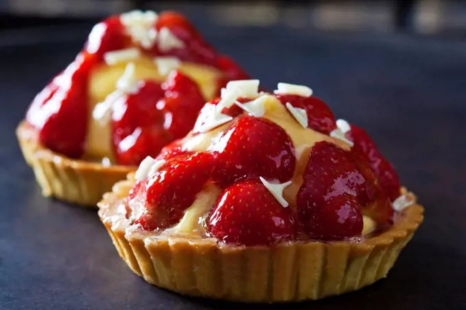 Strawberry tartlets with custard and white chocolate shaving