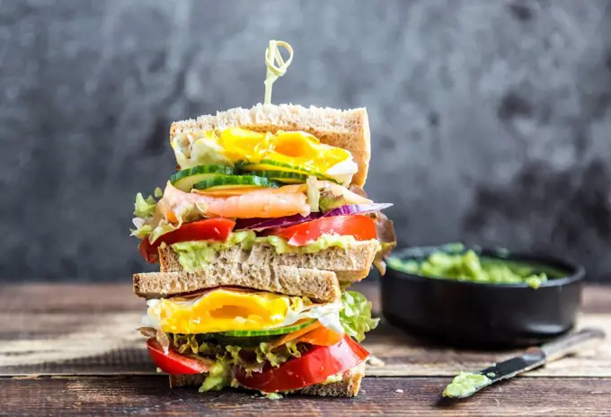 Sandwich with egg, salad, cucumber, tomate, salmon, avocado and onion