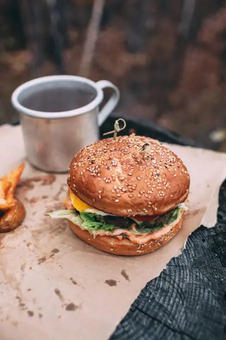 Burger and mug with tea on stamp