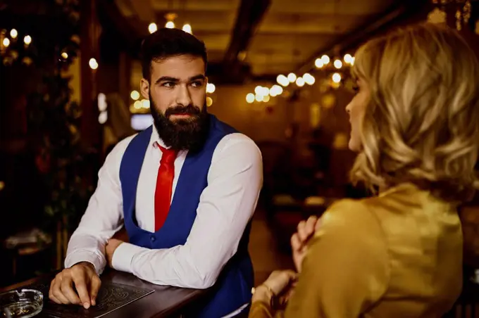 Fashionable young man looking at woman in a bar