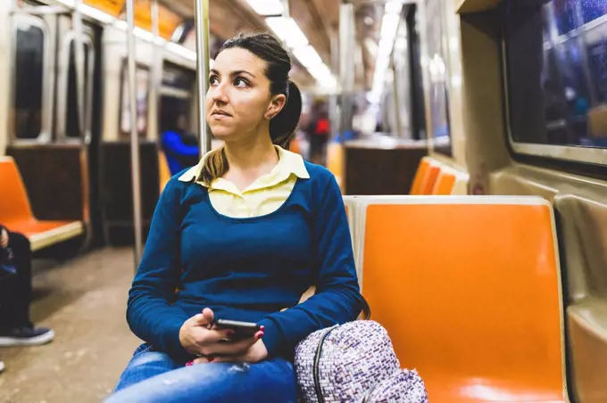 USA, New York, woman with cell phone in subway