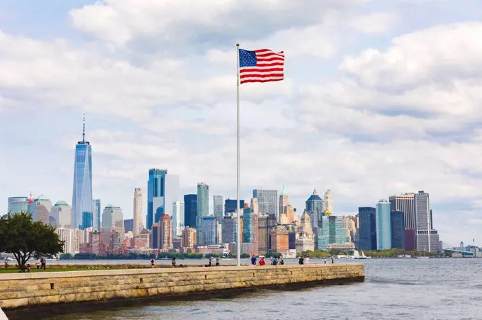 USA, New York, panoramic view of Manhattan with American Flag in the foreground