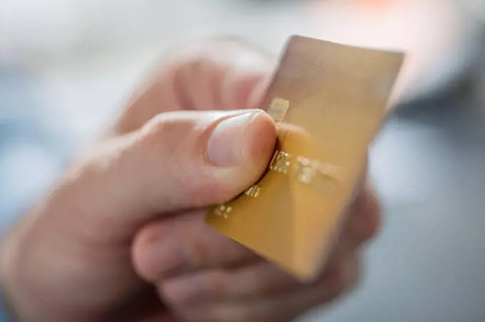 Man's hand holding credit card, close-up