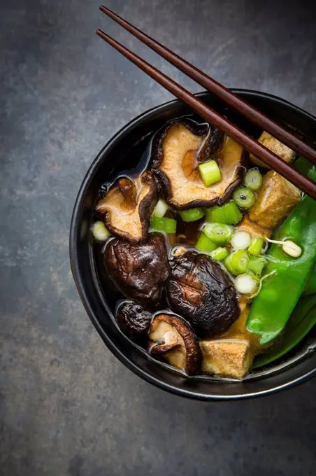 Japanese miso soup with sugar peas, shitake mushrooms, tofu and mung sprouts