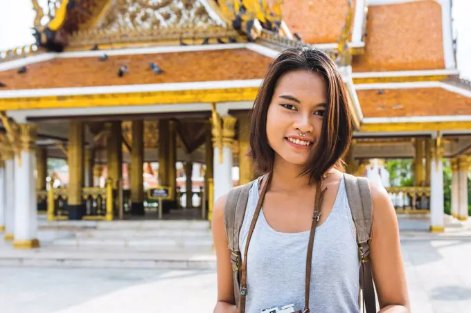 Thailand, Bangkok, portrait of smiling tourist with camera