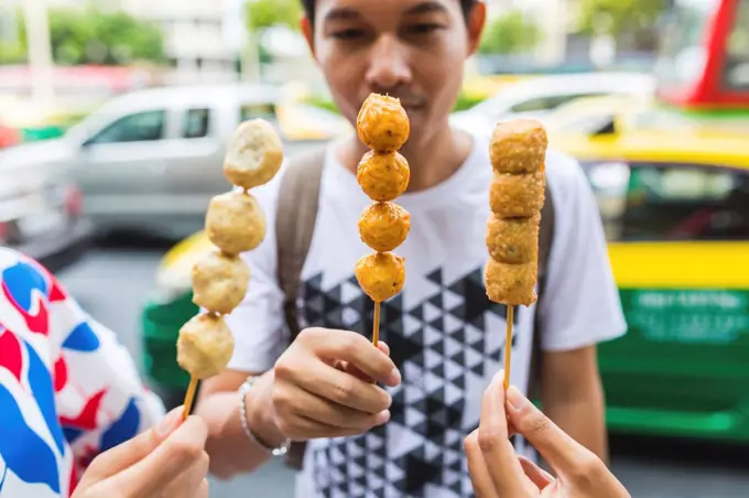 Thailand, Bangkok, group of friends eating street food, close-up