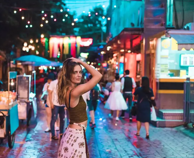 Thailand, Bangkok, young woman in the city on the street at night