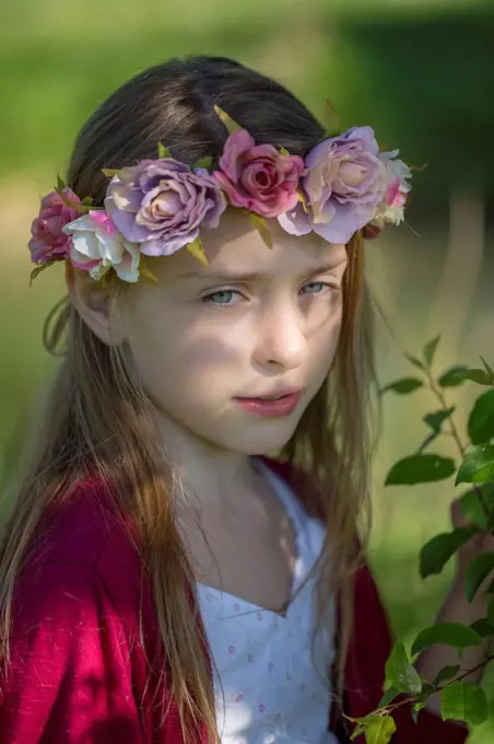 Portrait of daydreaming little girl wearing flowers