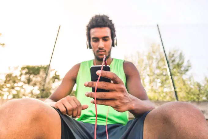 Basketball player listening music, smartphone and headphones