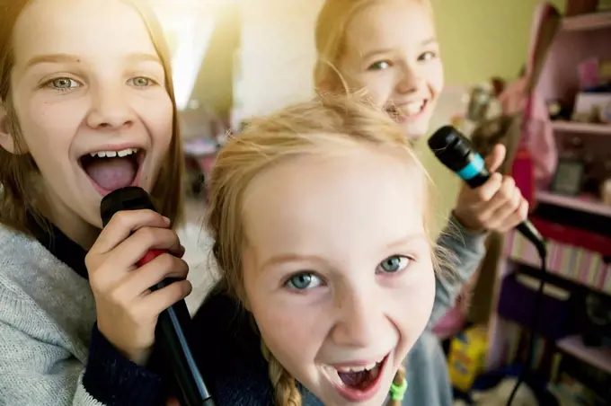 Three girls singing with microphone
