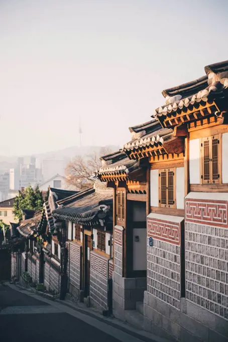 South Korea, Bukchon Hanok Village, street with traditional houses, Seoul Tower in the background