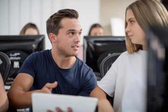 Teacher talking to student in computer class