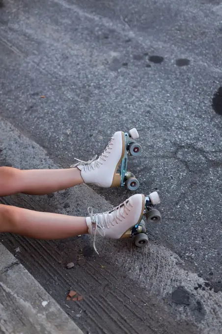 Young woman with roller skates on lane, partial view