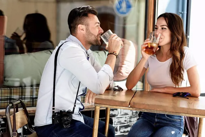 Couple having a drink at an outdoor bar in the city