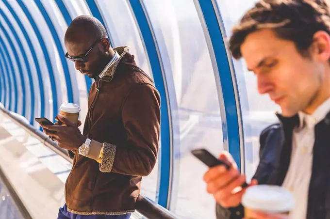 Businessmen with coffee to go using smartphone