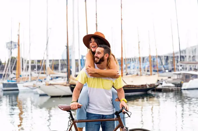 Spain, Barcelona, happy couple with bicycle at the seaside