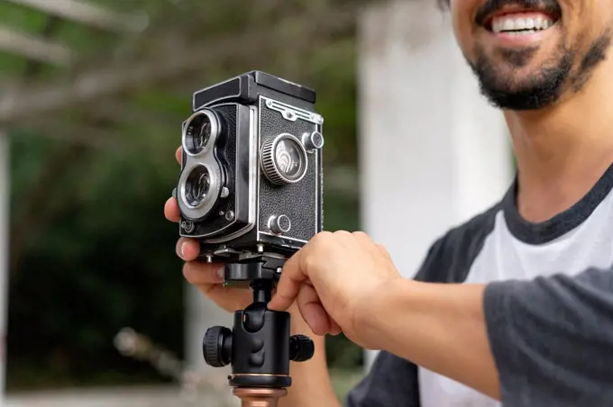 Close-up of happy young man using vintage camera