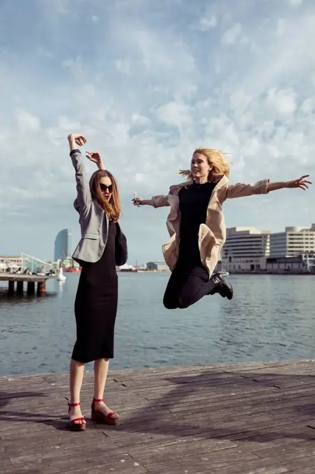Spain, Barcelona, two fashionable young women having fun